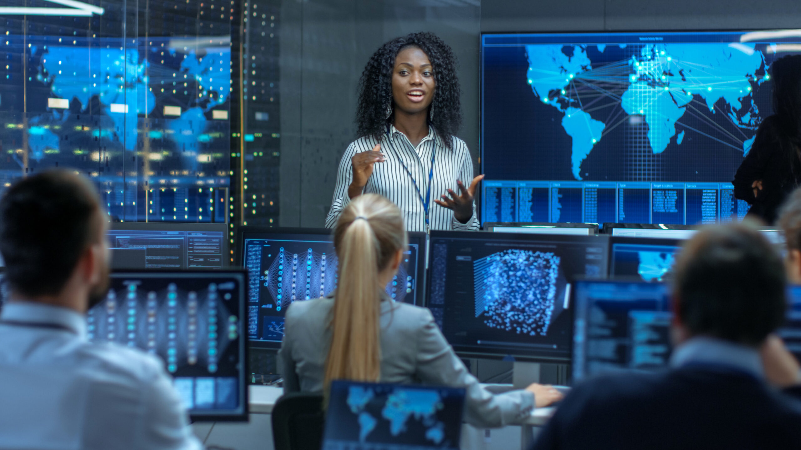 Chief Project Engineer Holds Briefing for a Team of Scientists that are Building Machine Learning System. Displays Show Working Model of Neural Network.